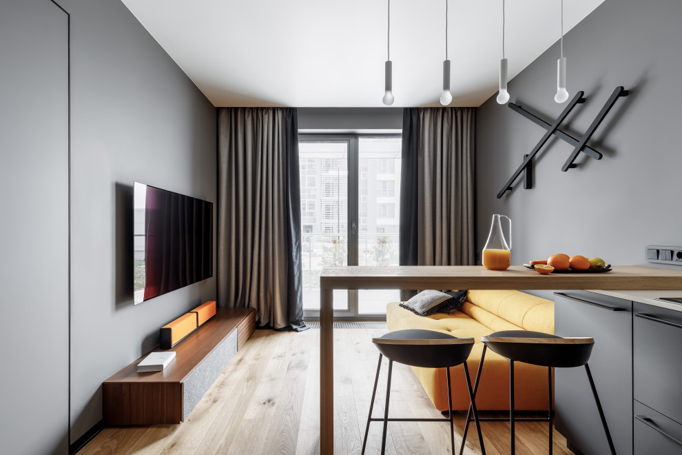 Idee per un soggiorno contemporaneo aperto con pareti grigie, pavimento in legno massello medio, TV a parete e pavimento marrone