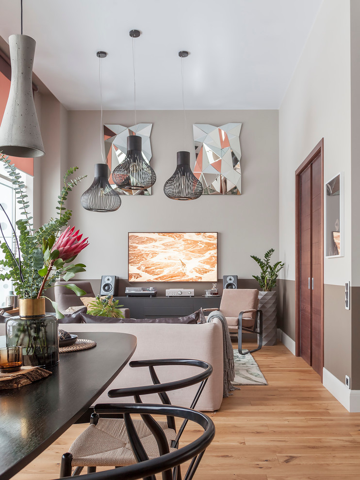 Mittelgroßes, Offenes Modernes Wohnzimmer mit grauer Wandfarbe, braunem Holzboden, TV-Wand und gelbem Boden in Sonstige
