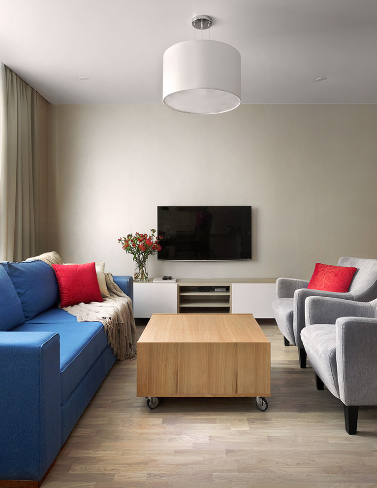 Diseño de salón abierto contemporáneo de tamaño medio con paredes beige, suelo de madera en tonos medios, televisor colgado en la pared y suelo beige