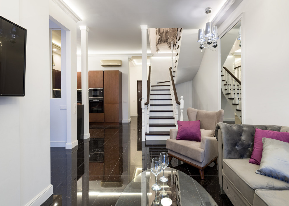 Immagine di un soggiorno tradizionale di medie dimensioni e stile loft con pareti bianche, pavimento in gres porcellanato, TV a parete e pavimento nero