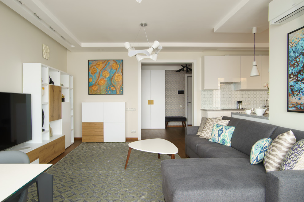 Пример оригинального дизайна: открытая, объединенная гостиная комната в современном стиле с белыми стенами, паркетным полом среднего тона, отдельно стоящим телевизором и коричневым полом