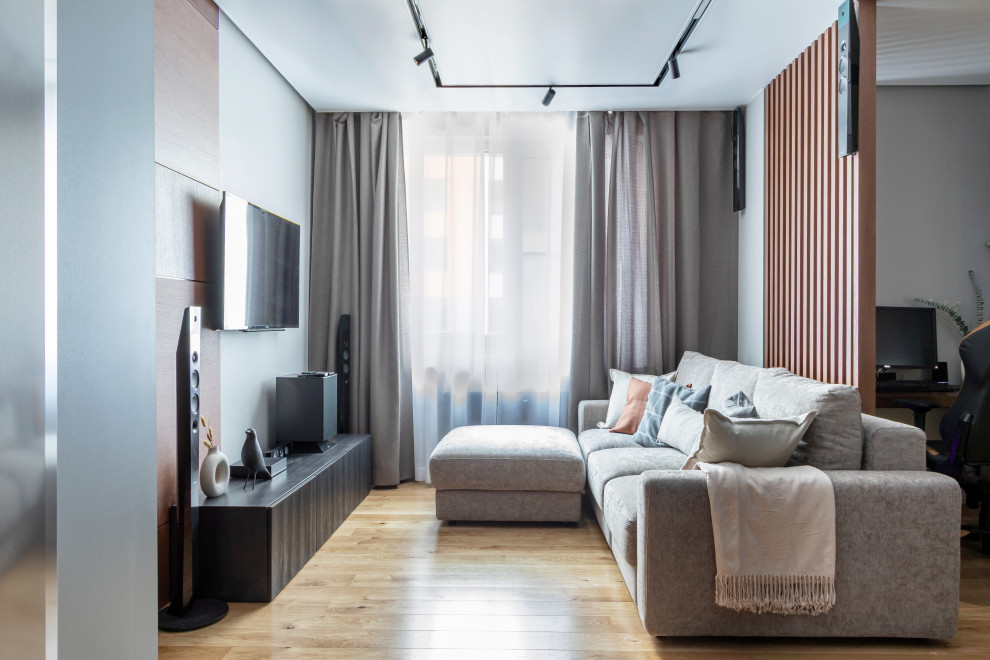 Esempio di un piccolo soggiorno design aperto con pareti grigie, pavimento in legno massello medio, nessun camino, TV a parete e pavimento beige
