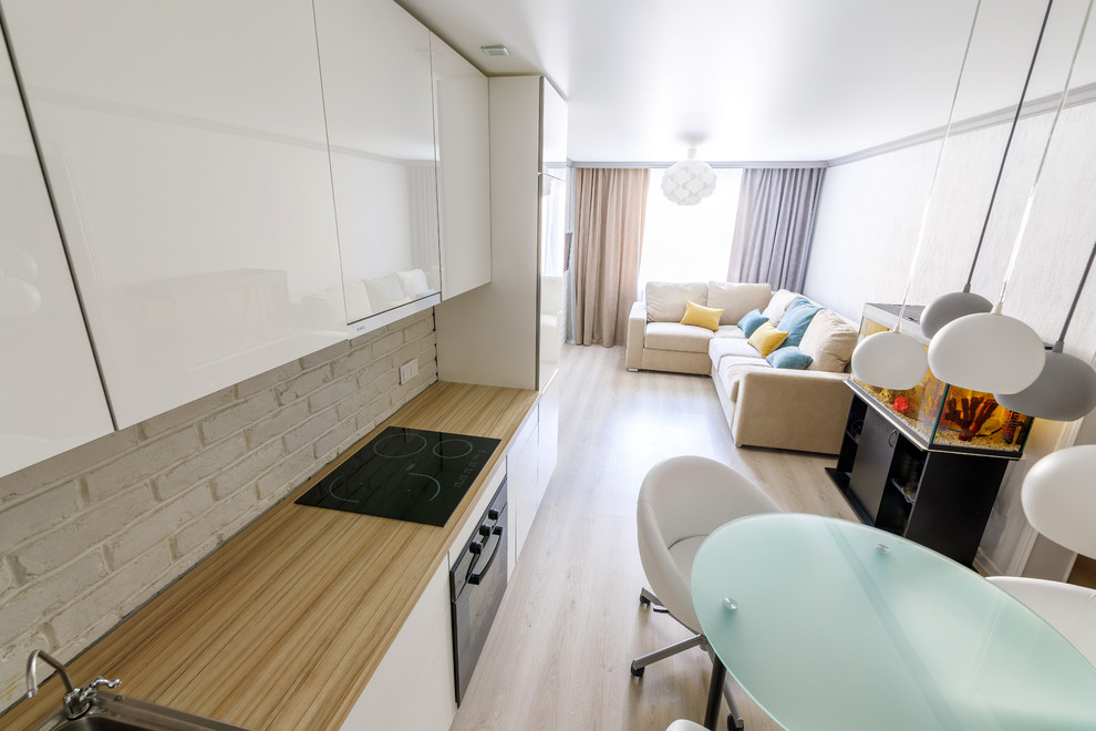 Diseño de salón abierto contemporáneo de tamaño medio con paredes blancas, suelo de madera en tonos medios, televisor colgado en la pared y suelo gris