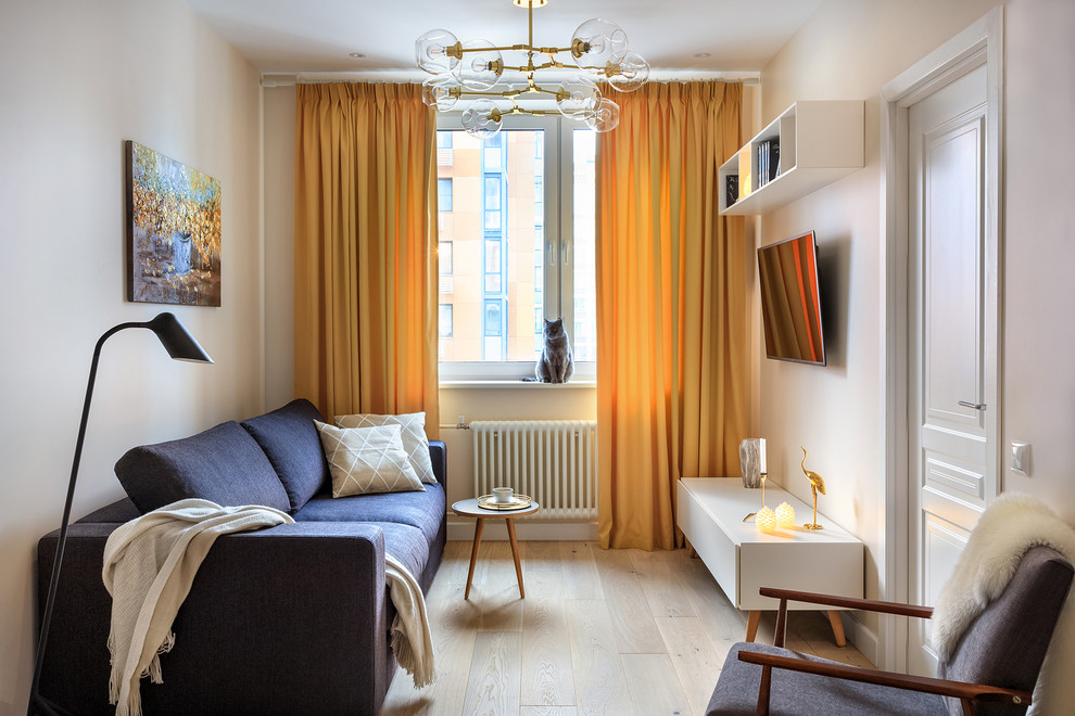 Esempio di un soggiorno nordico di medie dimensioni con pareti beige, parquet chiaro, TV a parete e pavimento beige