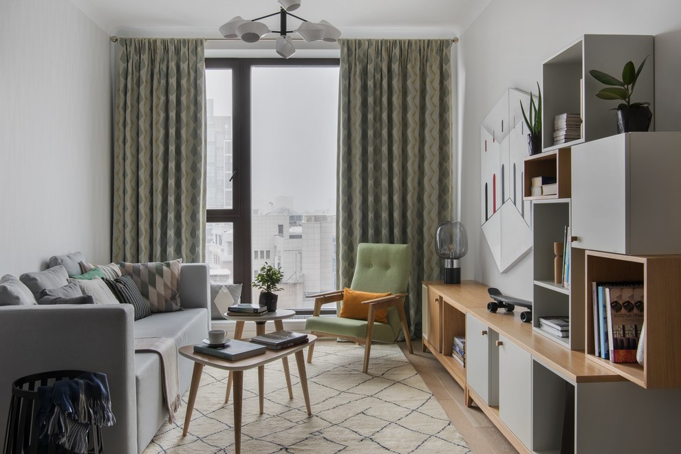 На фото: гостиная комната в современном стиле с серыми стенами, светлым паркетным полом и бежевым полом с
