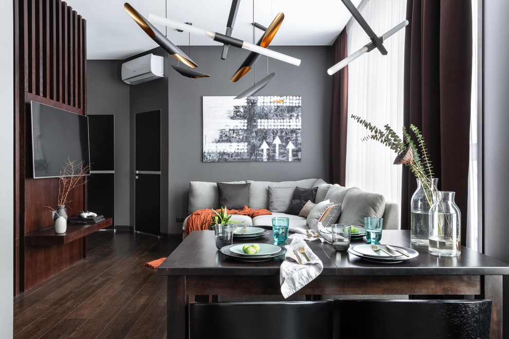 Esempio di un soggiorno contemporaneo di medie dimensioni e aperto con sala formale, pareti grigie, parquet scuro, TV a parete e pavimento marrone
