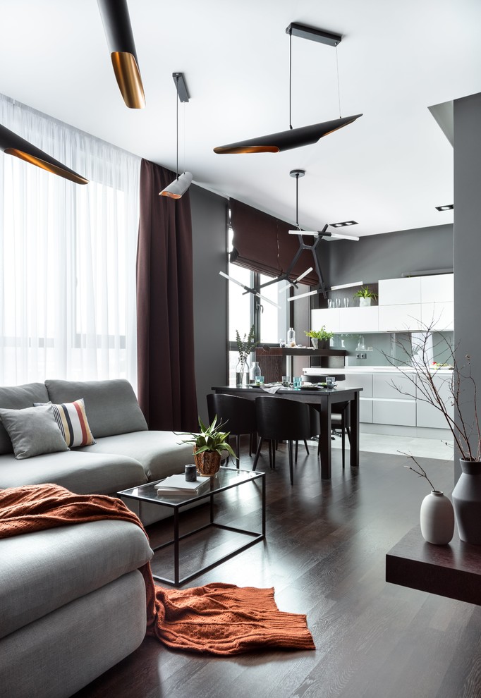 Esempio di un soggiorno design di medie dimensioni e aperto con sala formale, pareti grigie, parquet scuro, TV a parete e pavimento marrone