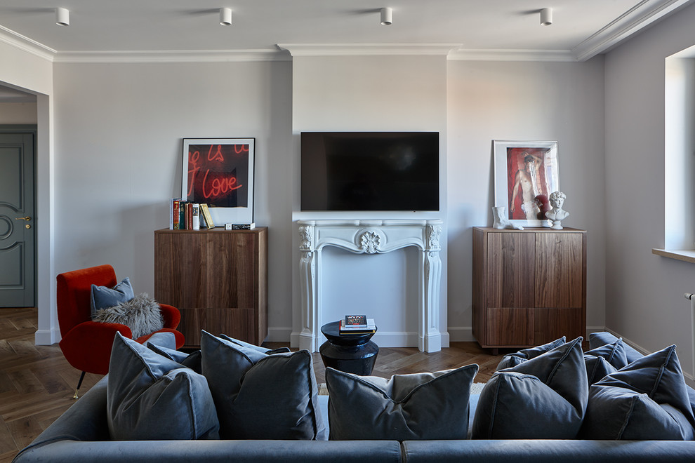 Idee per un soggiorno minimal con pareti grigie, pavimento in legno massello medio, camino classico e TV a parete