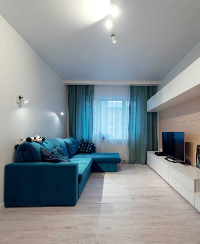 Idee per un piccolo soggiorno minimal chiuso con pareti bianche, pavimento in laminato e TV autoportante