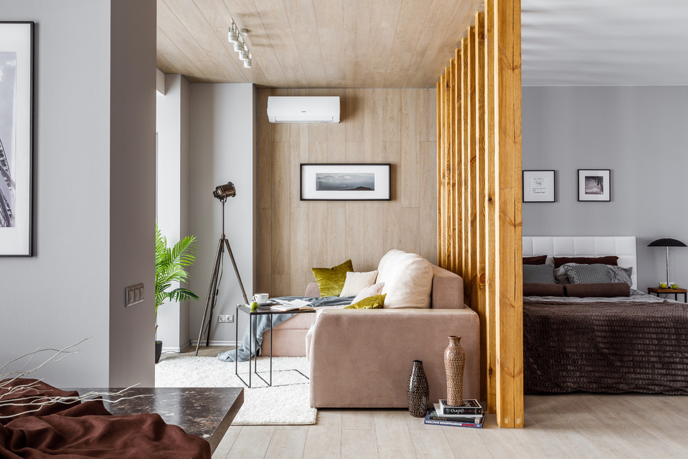 Cette image montre un salon design ouvert et de taille moyenne avec une salle de réception, parquet clair, un sol beige, un mur gris et un téléviseur fixé au mur.