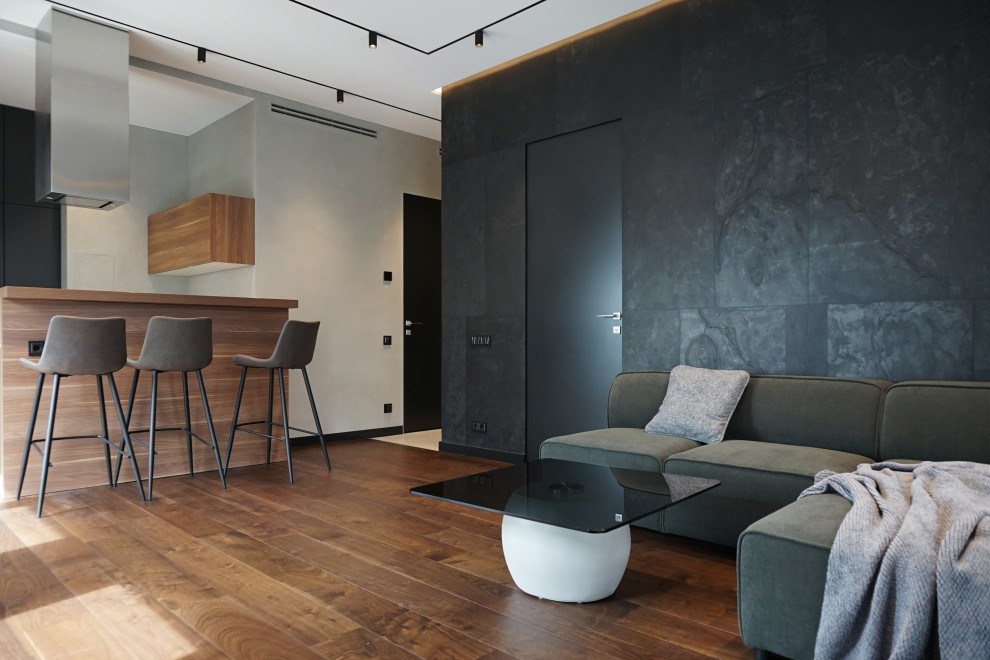 Пример оригинального дизайна: открытая гостиная комната среднего размера в современном стиле с серыми стенами, паркетным полом среднего тона и телевизором на стене