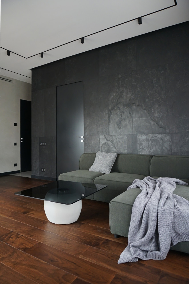 Пример оригинального дизайна: открытая гостиная комната среднего размера в современном стиле с серыми стенами, паркетным полом среднего тона и телевизором на стене