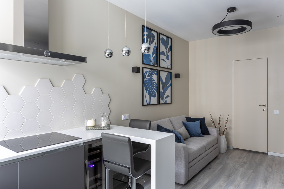 Esempio di un piccolo soggiorno contemporaneo aperto con pareti beige, pavimento in laminato, TV a parete e pavimento grigio