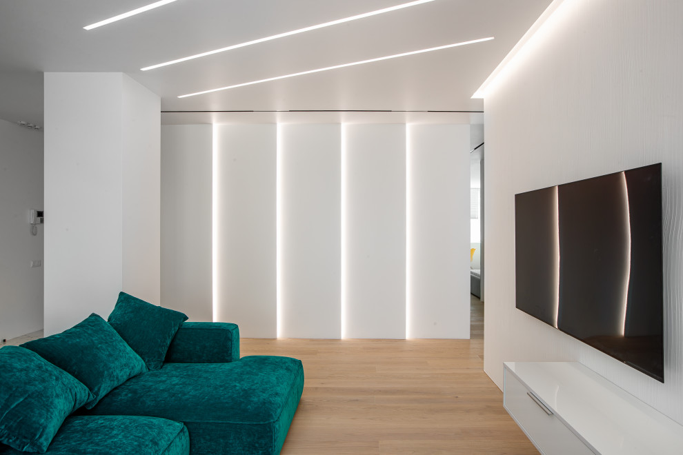 На фото: открытая гостиная комната в современном стиле с белыми стенами, светлым паркетным полом, телевизором на стене и бежевым полом с