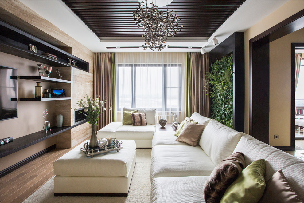 Inspiration pour un salon design de taille moyenne et ouvert avec une salle de réception, un mur beige, un sol en bois brun, un téléviseur fixé au mur et un sol beige.