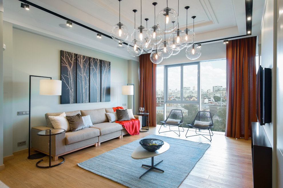 Idee per un soggiorno contemporaneo aperto con sala formale, TV a parete e parquet chiaro