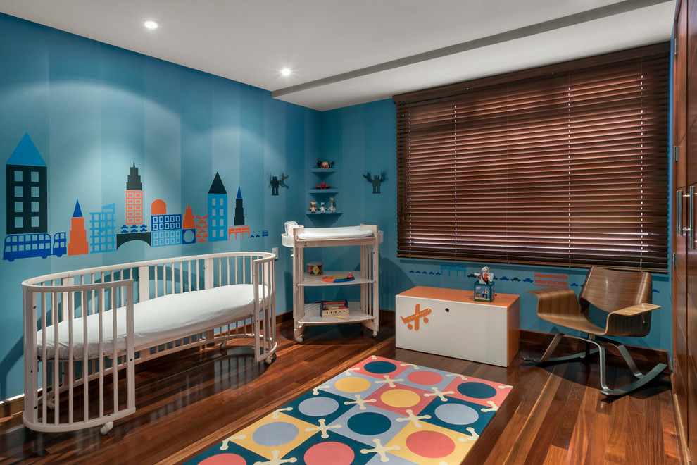 Esempio di una cameretta per neonato contemporanea con pareti blu, parquet scuro e pavimento marrone