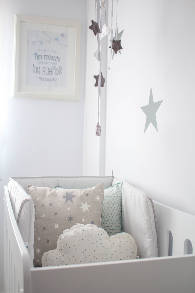 Réalisation d'une petite chambre de bébé neutre nordique avec un mur blanc et un sol en bois brun.