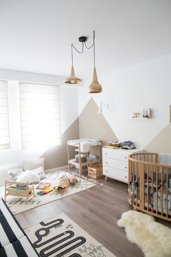 Réalisation d'une chambre de bébé neutre nordique avec un mur blanc, parquet foncé et un sol marron.