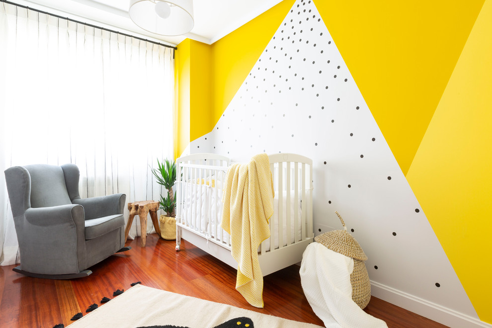 На фото: нейтральная комната для малыша в морском стиле с разноцветными стенами и паркетным полом среднего тона с
