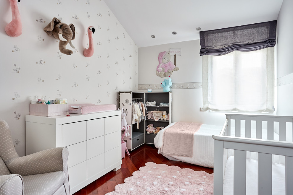 На фото: комната для малыша среднего размера в скандинавском стиле с темным паркетным полом, коричневым полом и синими стенами для девочки с