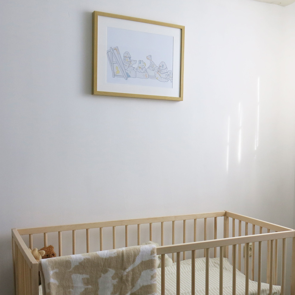Modelo de habitación de bebé neutra escandinava de tamaño medio con paredes blancas y suelo de madera clara