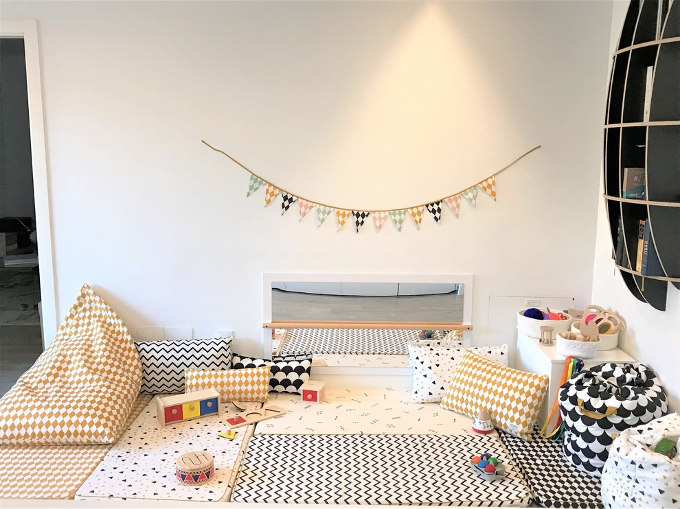 Cette photo montre une chambre de bébé neutre moderne de taille moyenne avec un mur blanc, un sol en bois brun et un sol marron.