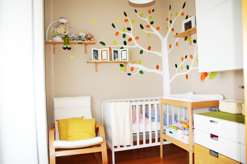 Inspiration för ett mellanstort funkis könsneutralt babyrum, med flerfärgade väggar och mellanmörkt trägolv