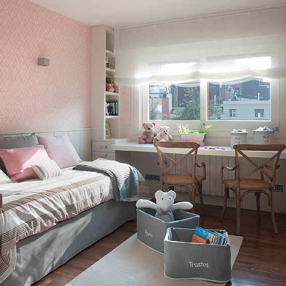 This is an example of a medium sized shabby-chic style nursery for girls in Barcelona with multi-coloured walls and medium hardwood flooring.