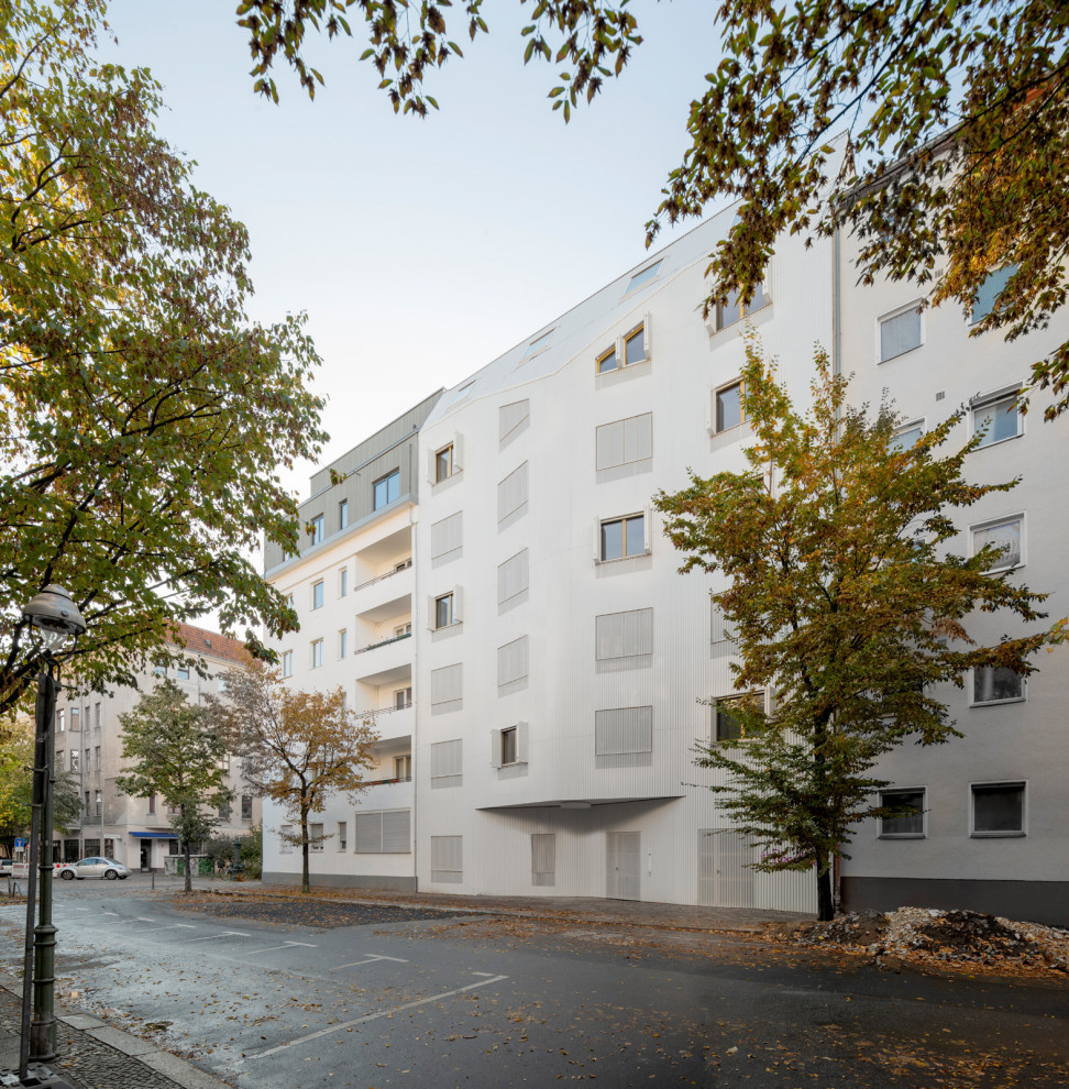 Großes, Dreistöckiges Modernes Haus mit Metallfassade, weißer Fassadenfarbe und Mansardendach in Berlin