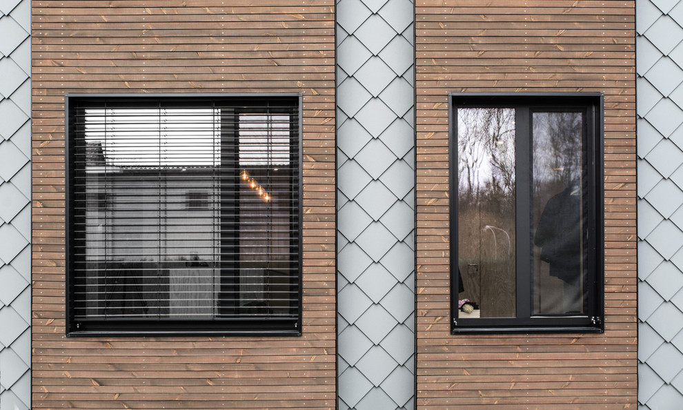 Mittelgroßes, Zweistöckiges Modernes Haus mit grauer Fassadenfarbe, Satteldach und Blechdach in Sonstige