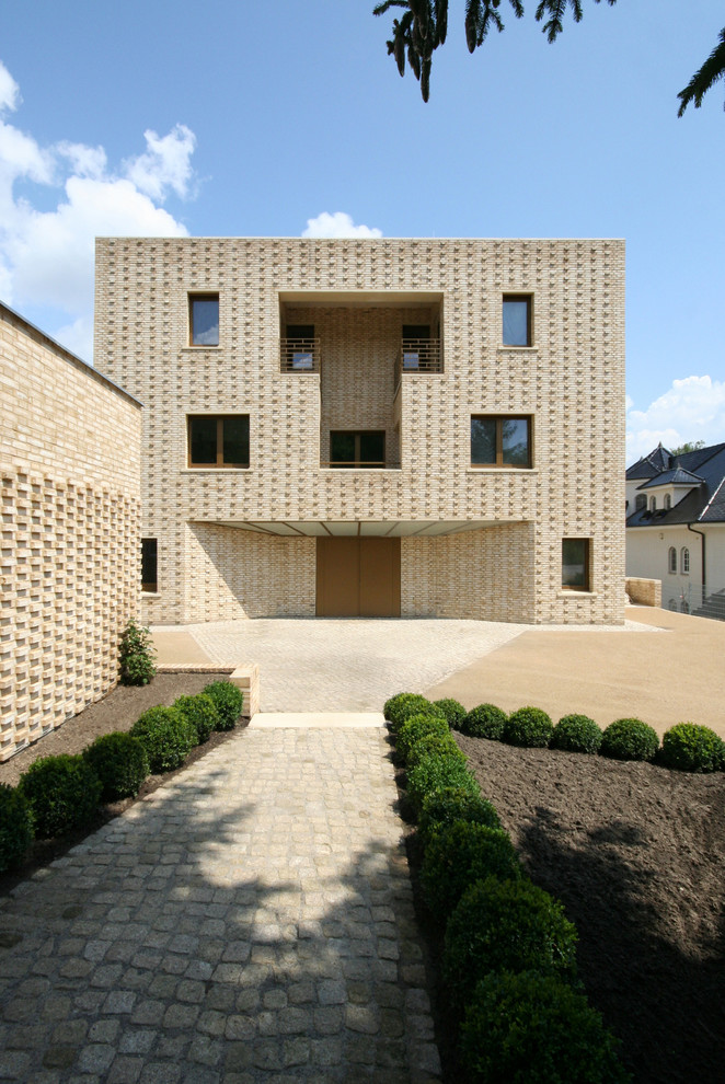 Inspiration for a large mediterranean three-story brick flat roof remodel in Berlin