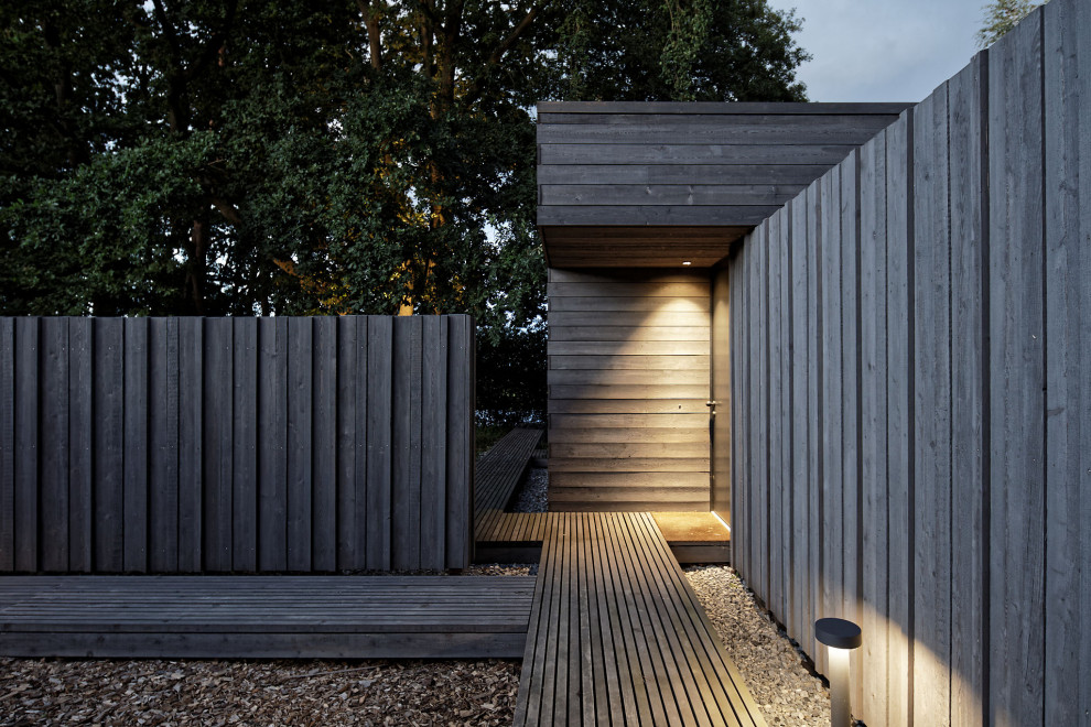 Идея дизайна: одноэтажный, деревянный, серый частный загородный дом среднего размера в стиле модернизм с плоской крышей