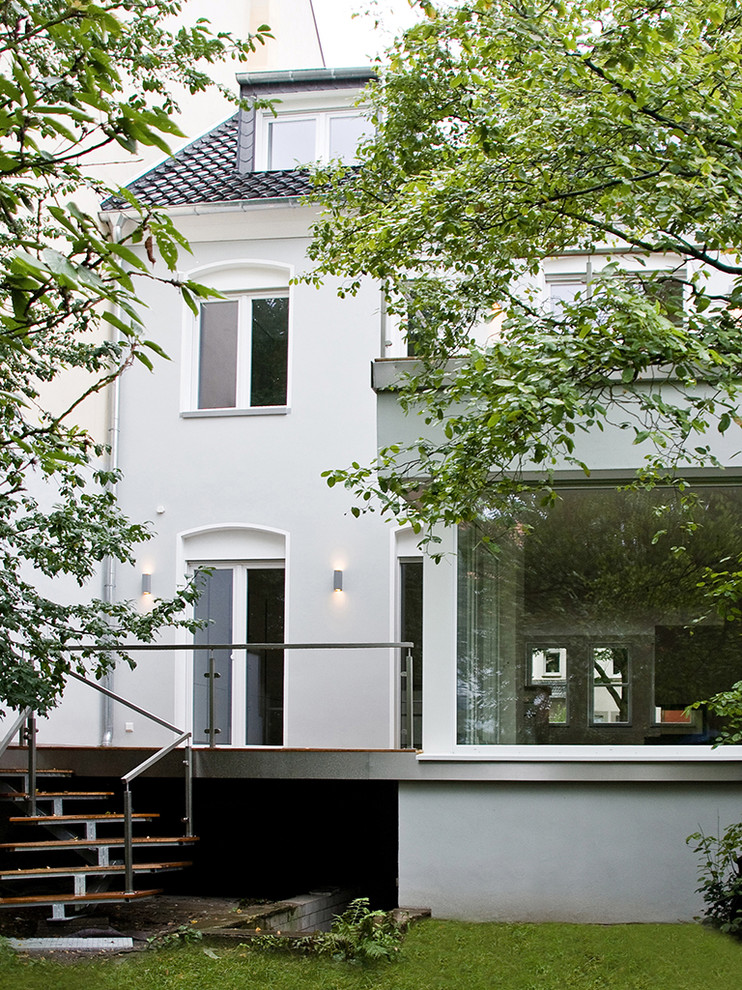 Foto della facciata di una casa bianca contemporanea a due piani con rivestimento in stucco