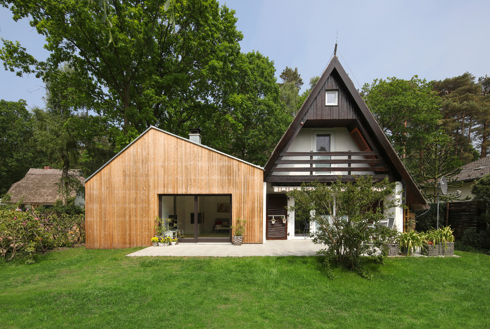 Cette image montre une façade de maison design en bois à un étage avec un toit à deux pans.