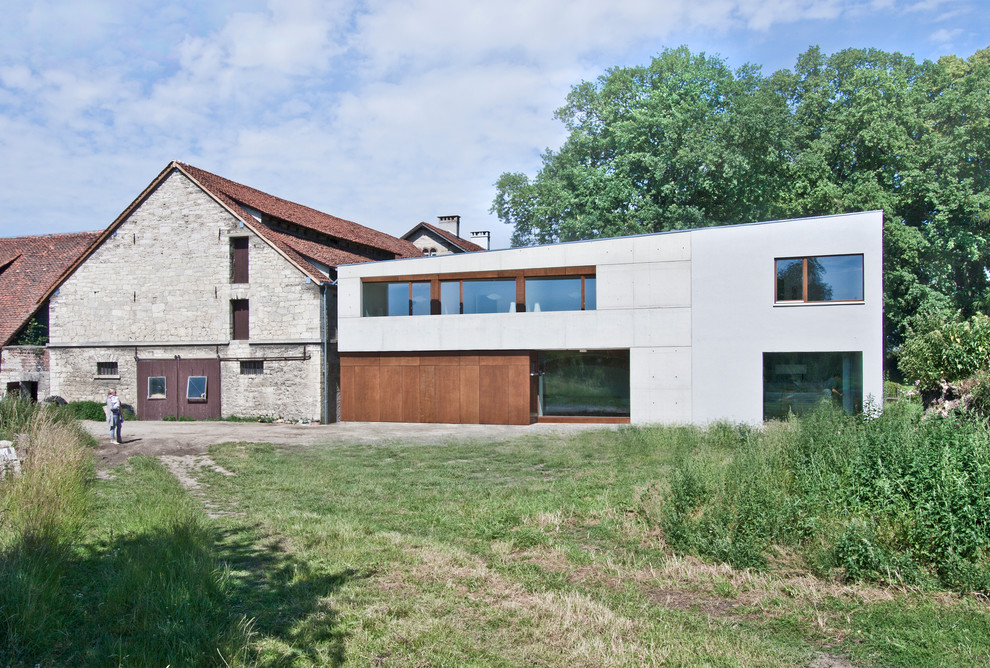 Cette image montre une façade de maison blanche design à un étage et de taille moyenne avec un revêtement mixte et un toit en appentis.
