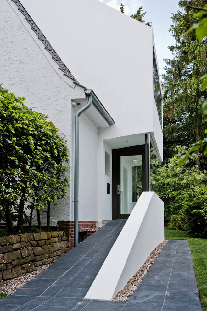 Ejemplo de fachada de casa blanca clásica grande de tres plantas con revestimiento de estuco, tejado a dos aguas y tejado de teja de barro