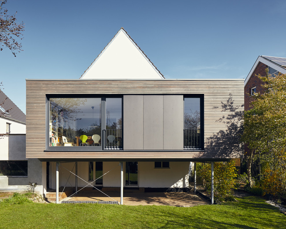 Kleine, Einstöckige Moderne Holzfassade Haus mit brauner Fassadenfarbe und Flachdach in Düsseldorf