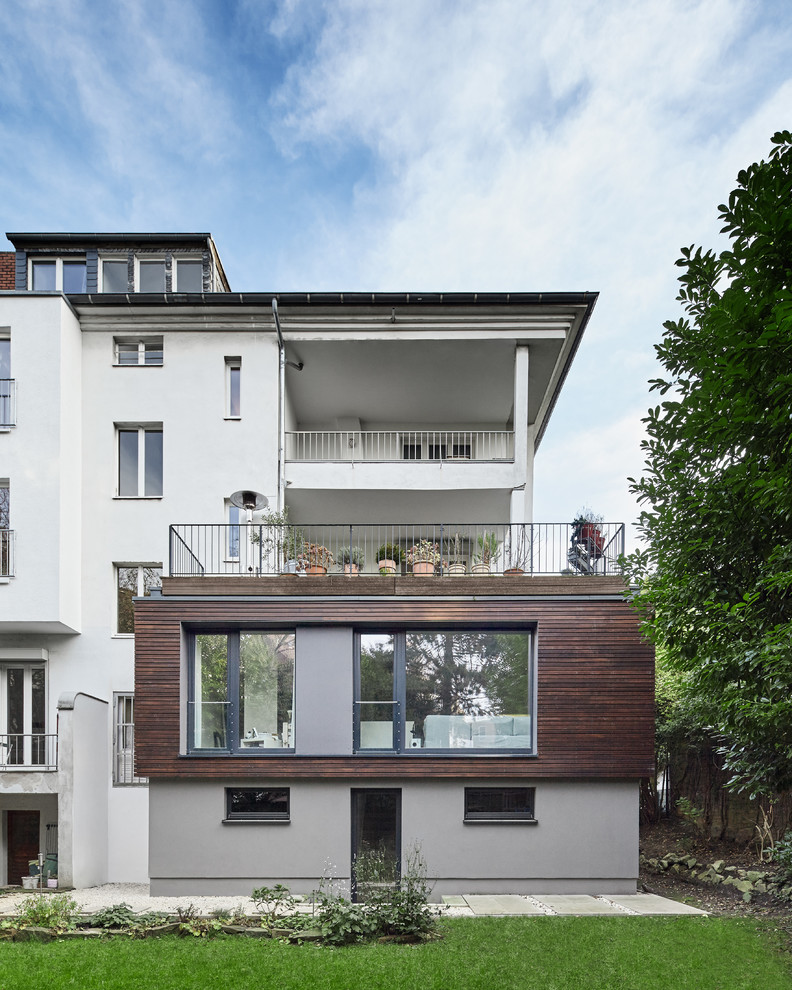 Esempio della facciata di una casa grigia contemporanea a tre piani di medie dimensioni con rivestimento in legno e tetto piano