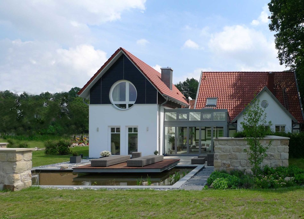 Inspiration for a large scandinavian white split-level mixed siding gable roof remodel in Hanover