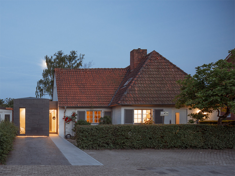 Idée de décoration pour une façade de maison blanche vintage en brique avec un toit à deux pans.