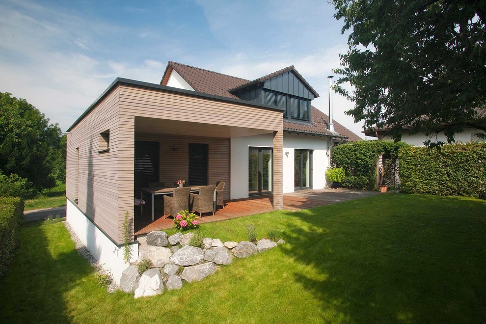 Diseño de fachada marrón actual pequeña de dos plantas con revestimiento de madera y tejado plano