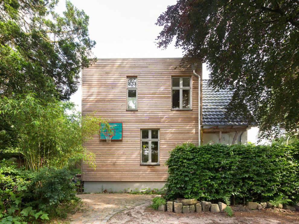 Inspiration för mellanstora moderna bruna hus, med två våningar och platt tak