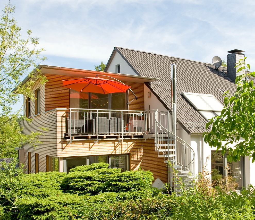 Diseño de fachada de casa blanca contemporánea de tamaño medio de dos plantas con revestimiento de madera y tejado plano