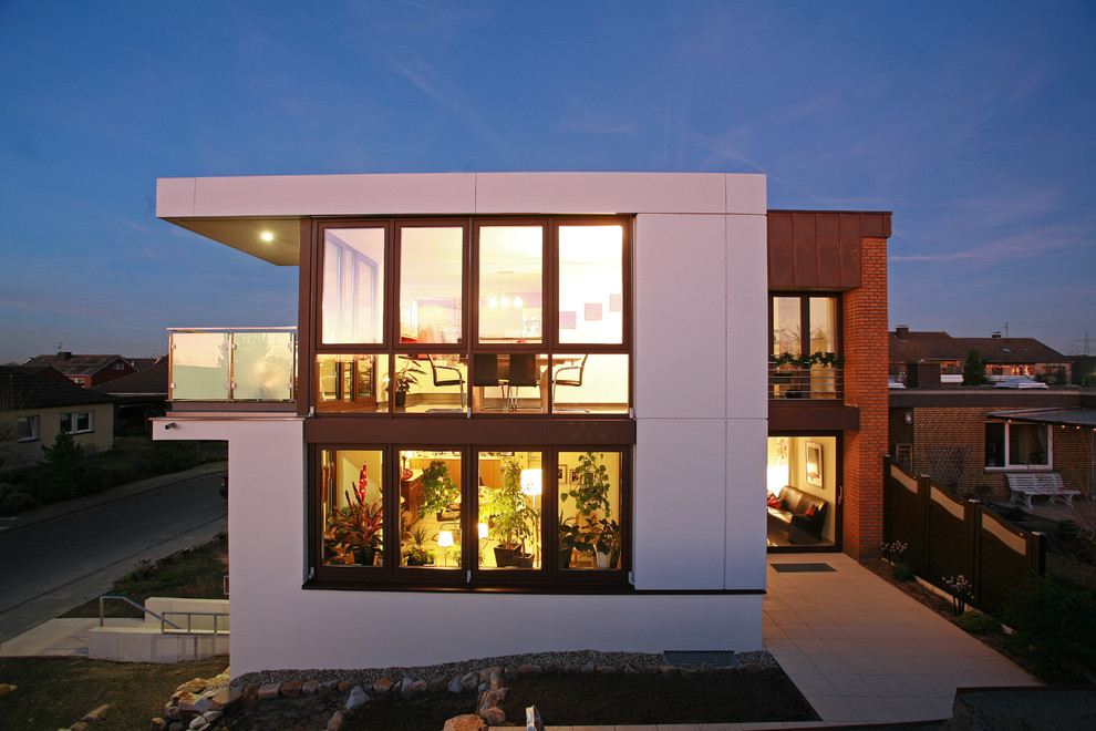 Стильный дизайн: огромный, двухэтажный, белый частный загородный дом в современном стиле с плоской крышей - последний тренд
