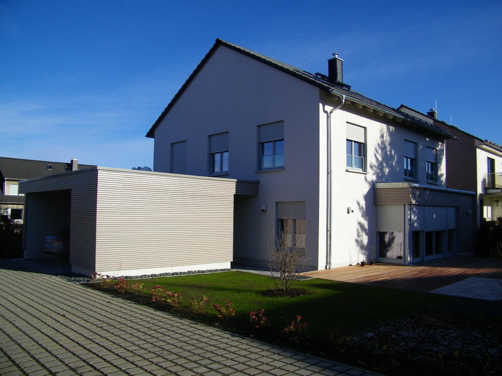 Réalisation d'une façade de maison grise design en stuc de taille moyenne et à un étage avec un toit à deux pans et un toit en tuile.
