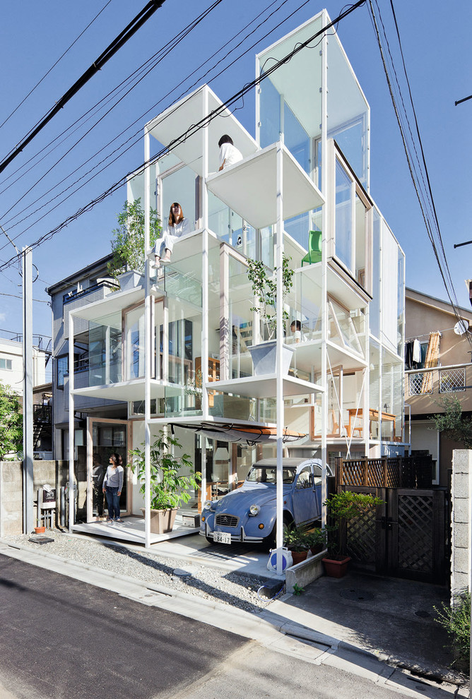 Cette photo montre une petite façade de maison blanche tendance à deux étages et plus avec un revêtement mixte.