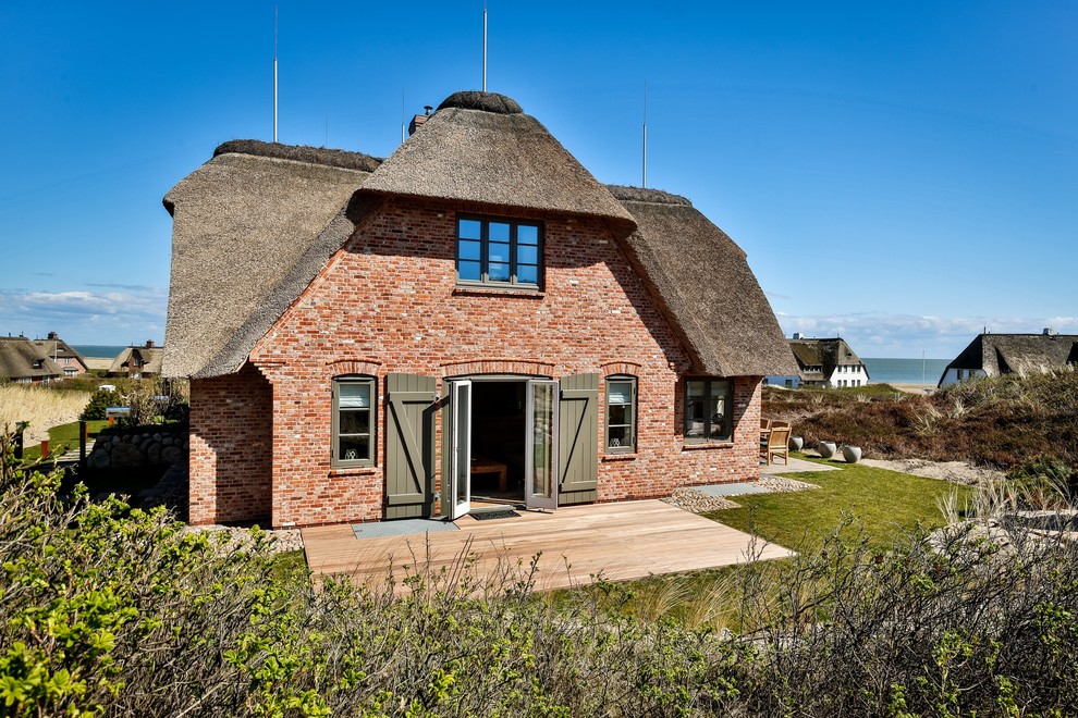 Diseño de fachada de casa multicolor escandinava grande de dos plantas con revestimiento de ladrillo y tejado a doble faldón