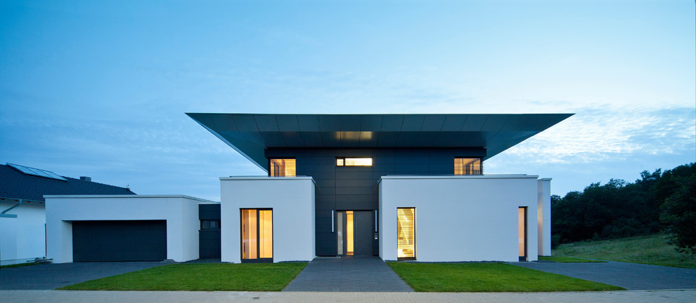 Пример оригинального дизайна: двухэтажный, разноцветный дом в современном стиле с плоской крышей и облицовкой из цементной штукатурки