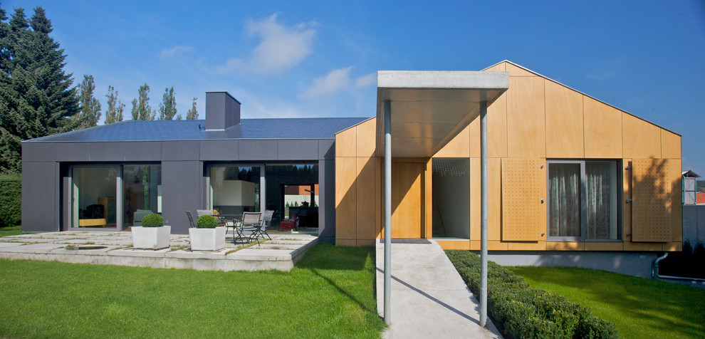 Idée de décoration pour une grande façade de maison grise design de plain-pied avec un revêtement mixte et un toit à deux pans.